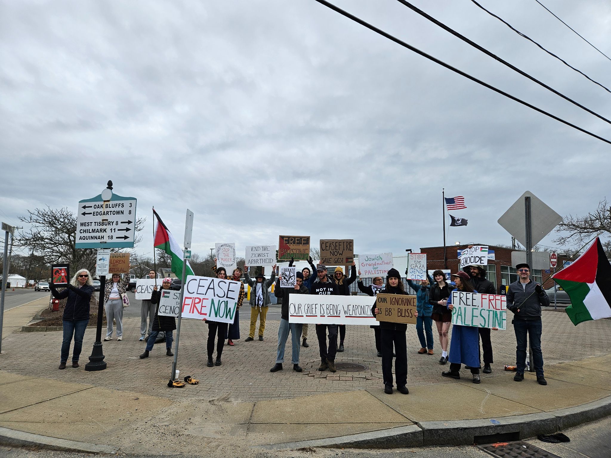 MV For Palestine members standing on the sidewalk holding signs demanding a ceasefire